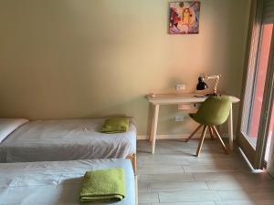 Zimmer mit 2 Betten und einem Schreibtisch mit Stuhl in der Unterkunft Lisonino House in SantʼAngelo Lodigiano