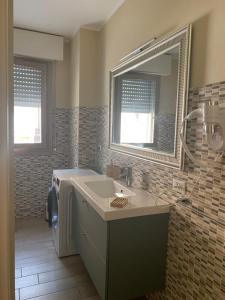 ein Badezimmer mit Waschbecken und Spiegel in der Unterkunft Lisonino House in SantʼAngelo Lodigiano + 15 Fotos