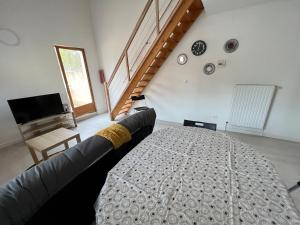a living room with a bed and a couch at La Maisonnette Un Séjour à Part in Longeville-lès-Metz