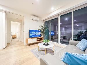 - un salon avec un canapé et une télévision dans l'établissement Close To Mel Uni 2br 2ba Parking Balconywifigy, à Melbourne