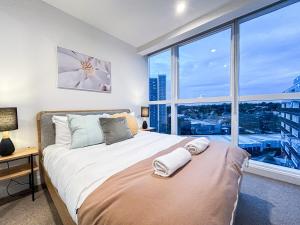1 dormitorio con 1 cama y ventana grande en Close To Mel Uni 2br 2ba Parking Balconywifigy en Melbourne