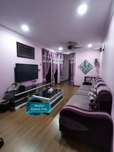 a living room with a couch and a flat screen tv at Homestay Temerloh Jaya in Temerloh