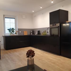 cocina con armarios negros y encimera en Ferienwohnung in Hohen Neuendorf bei Berlin, Zentral gelegen, en Hohen Neuendorf