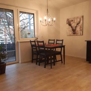 comedor con mesa, sillas y lámpara de araña en Ferienwohnung in Hohen Neuendorf bei Berlin, Zentral gelegen, en Hohen Neuendorf