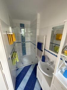 a white bathroom with a shower and a sink at Haus Apricum - schön wohnen & gratis parken in Vienna