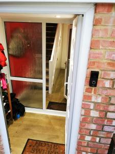 un ingresso a una casa con porta scorrevole in vetro di Unique, Stylish, Non-smoking, Riverview Loft EnSuite for Rent a Erith