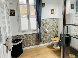 uma casa de banho com um WC e uma janela em L'inattendue em Pierrefonds