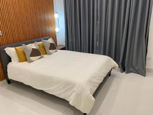 um quarto com uma cama com lençóis brancos e almofadas em Moderno y acogedor apartamento en Santo Domingo. em Santo Domingo