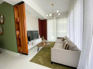 uma sala de estar com um sofá e uma televisão em Moderno y acogedor apartamento en Santo Domingo. em Santo Domingo