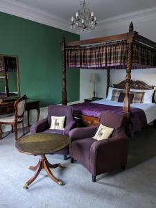 a bedroom with a bed and a couch and a table at Bennachie Lodge Hotel in Kemnay in Inverurie