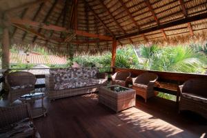 an outdoor patio with wicker furniture and a roof at Villa Éden in Alter do Chao