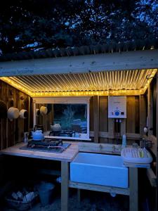 a kitchen with a stove and a counter with lights at The Yurt @ Penbanc Pasture in Cardigan