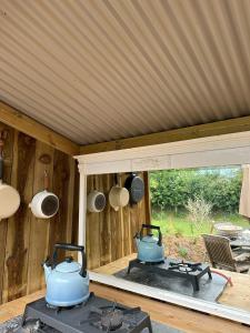 a kitchen with two pots and pans on a stove at The Yurt @ Penbanc Pasture in Cardigan