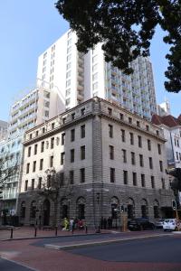 un edificio antiguo en una calle de la ciudad con edificios altos en Private Luxury Residence 906 at TAJ Cape Town, en Ciudad del Cabo