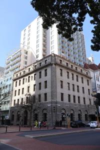 an old building on a city street with tall buildings at Private Luxury Residence 906 at TAJ Cape Town in Cape Town