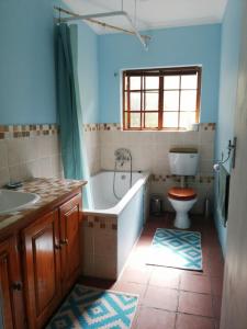 a bathroom with a tub and a toilet and a sink at Bushman's Pillow in Sanddrif