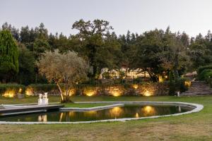 un laghetto in un giardino con due persone intorno di The Fox House - Private Villa & Nature a São Pedro do Sul