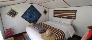 a bedroom with a white bed with a hat on it at Q'OTA TAYPY LODGE in Puno