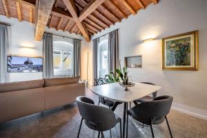 Dimora Collection - Le Torri - Boutique Luxury Suites - Adults Only في فلورنسا: غرفة معيشة مع أريكة وطاولة وكراسي