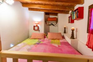 1 dormitorio con 1 cama grande con una manta colorida en B&b Selu en Jerzu