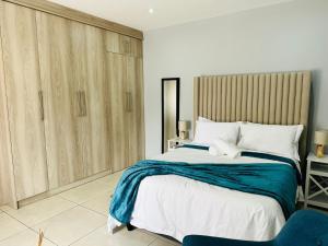 una camera con un grande letto e una sedia blu di Royal Mansion Lodge a Johannesburg
