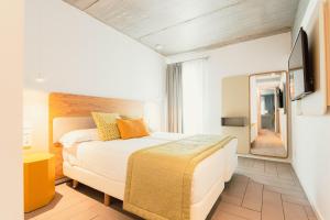 - une chambre d'hôtel avec un lit et un miroir dans l'établissement Resort Cordial Santa Águeda & Perchel Beach Club, à Playa de Arguineguín