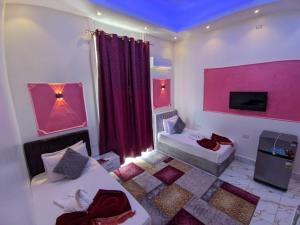 Pokój z 2 łóżkami i różową ścianą w obiekcie Hotel New One w Kairze