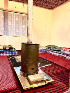 an old stove in a room with two beds at Spiti Horizon Homestay in Kaza