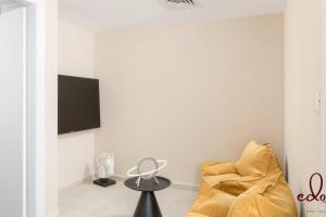 ein Wohnzimmer mit einem Stuhl und einem TV in der Unterkunft View דירה משפחתית במיקום הטוב באילת in Eilat