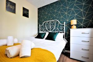 a bedroom with a bed with a black and white headboard at Manchester Townhouse by BEVOLVE - 4 bedrooms - Free Parking in Manchester