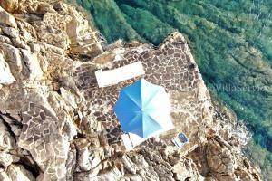 a blue umbrella sitting on the side of a mountain at Villa Mare Blu - Porto Rotondo in Porto Rotondo +51 photos