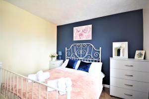a bedroom with a white bed and a blue wall at Manchester Townhouse by BEVOLVE - 4 bedrooms - Free Parking in Manchester