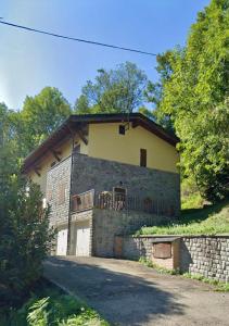 uma grande casa de tijolos com uma varanda em cima em Villetta selve em Fiumalbo