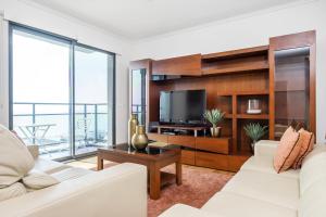 sala de estar con 2 sofás blancos y TV en Blue and Gold Sunset By Madeira Sun Travel en Funchal