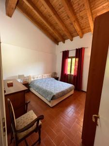 um quarto com uma cama, uma secretária e uma cadeira em Villetta selve em Fiumalbo