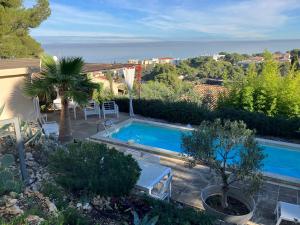 a swimming pool in a garden with a view at Les Restanques De L' Etang in Martigues
