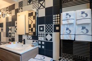 uma casa de banho com lavatório, espelho e toalhas em Taggami b&b em Nocera Inferiore