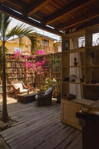 a patio with a library with chairs and a palm tree at Eco Lodge Mancora in Máncora