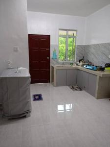 a large white kitchen with a sink and a mirror at Homestay Usrati No. 17K (untuk muslims sahaja) in Kangar