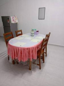 a table with chairs and a pink table cloth on it at Homestay Usrati No. 17K (untuk muslims sahaja) in Kangar