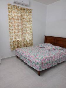 a bedroom with a bed and a window with a curtain at Homestay Usrati No. 17K (untuk muslims sahaja) in Kangar
