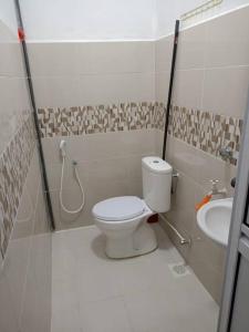 a small bathroom with a toilet and a sink at Homestay Usrati No. 17K (untuk muslims sahaja) in Kangar