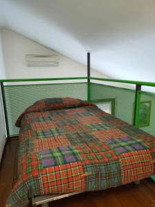 uma cama com um cobertor colorido num quarto em A casa di Rosa em Pádua