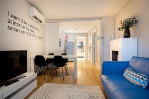 a living room with a blue couch and a table at Chiado Square Apartments | Lisbon Best Apartments in Lisbon