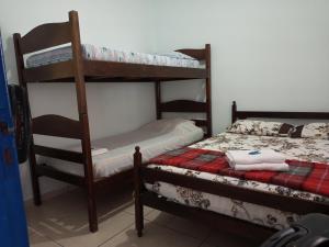 a bedroom with two bunk beds and a bed at Hostel Pé na praia - Quartos e Barracas Camping in Caraguatatuba