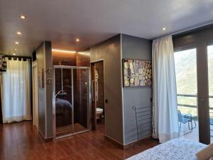 um quarto com uma cama e uma porta de vidro em Casita dúplex en Casa Rural Camp de Claror em Sant Julià de Lòria