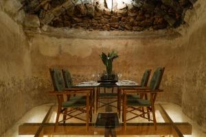 una sala da pranzo con tavolo, sedie e parete in pietra di Hotel Cesar Lanzarote a La Asomada