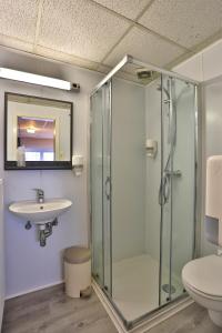 a bathroom with a glass shower and a sink at Chez Phil in Robertville