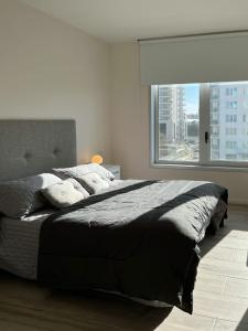 a bedroom with a large bed with a large window at Departamento de un dormitorio - AMARRAS CENTER in Santa Fe