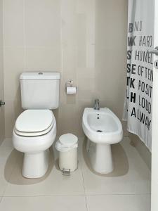 a white bathroom with a toilet and a sink at Departamento de un dormitorio - AMARRAS CENTER in Santa Fe